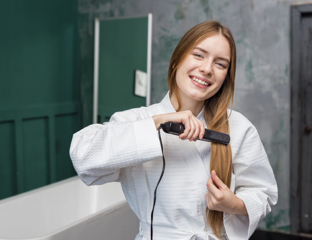 Woman straightening her hair with a wet-to-dry flat iron